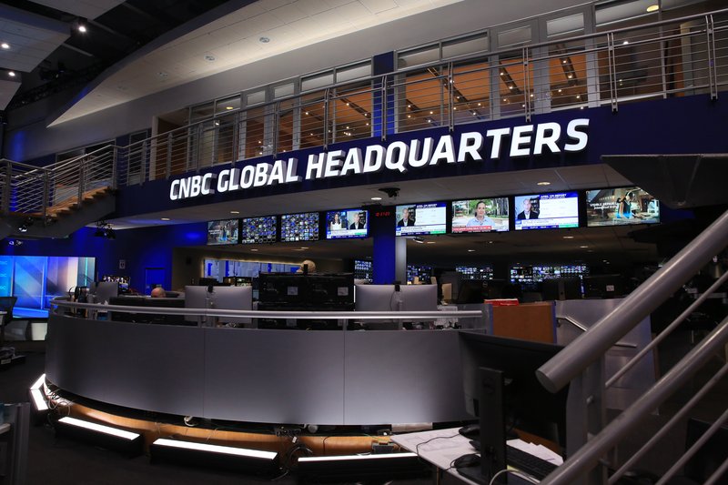 Newsroom im CNBC Global Headquarters: Arbeitsplätze mit Monitoren unter dem Schriftzug „CNBC Global Headquarters“.